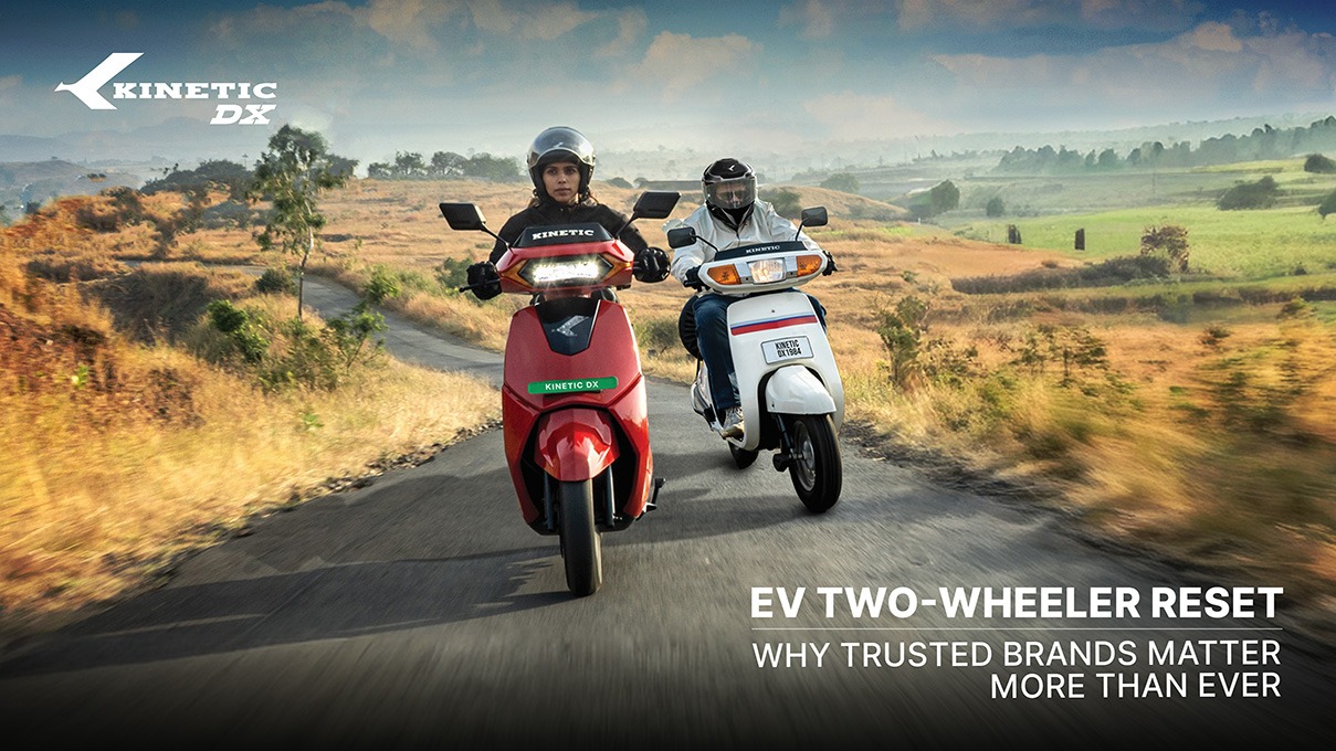 Two riders on Kinetic DX electric scooters riding on a rural Indian road highlighting reliability and trusted EV performance